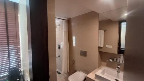 a bathroom with a shower and a toilet and a sink at THE WOODROSE in Bengaluru