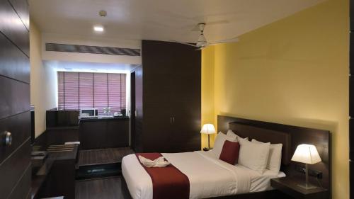 a bedroom with a large bed and a kitchen at THE WOODROSE in Bengaluru