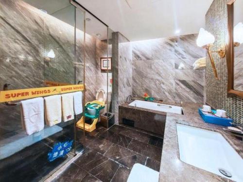 a bathroom with a large tub and a sink at Wuhan Gleetour Hotel in Wuhan