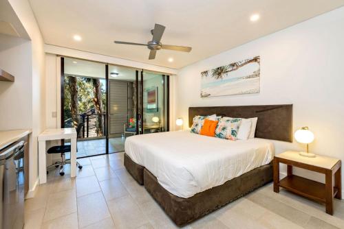 ein Schlafzimmer mit einem Bett und einem Schreibtisch in der Unterkunft Belle Escapes 228-229 Luxury Beachfront Resort Palm Cove in Palm Cove