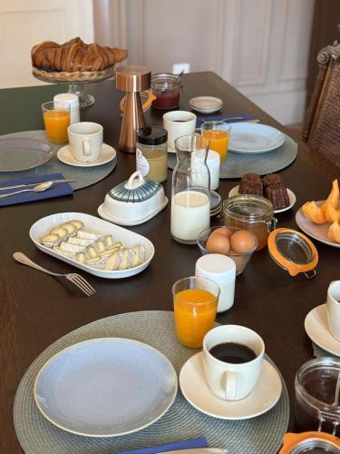 une table avec des assiettes et des tasses de café et des œufs dans l'établissement Maison Bel Air, à Romorantin-Lanthenay
