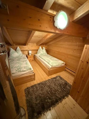 an attic room with two beds and a rug at Feriendorf Tauerngast in Hohentauern