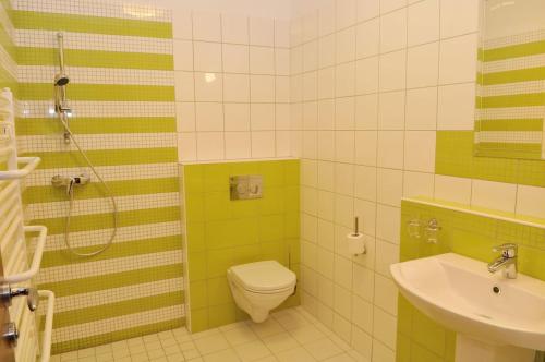 a green and white bathroom with a toilet and a sink at Mizse Motel in Lajosmizse