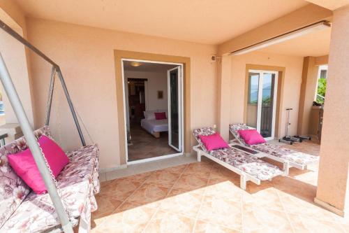 a living room with two couches and pink pillows at Apartments Mila Krimovica in Krimovice