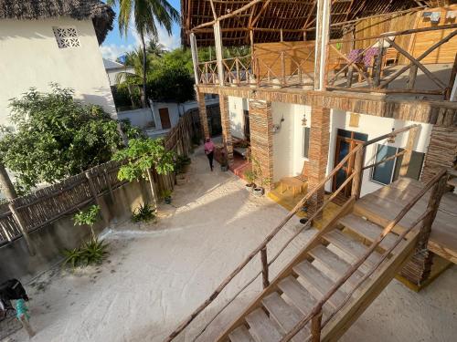 a woman walking down a street next to a building at Zanzibar beach escape 1&2 in Bwejuu