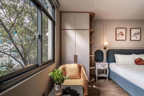 a bedroom with a bed and a window and a chair at SAZI RESIN HOTEL - Free Nails HairWash in Ho Chi Minh City