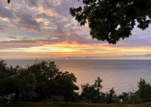 a view of the ocean at sunset at All the Waters Retro Home on Lake Michigan- Your Own PRIVATE BEACH in Benton Harbor
