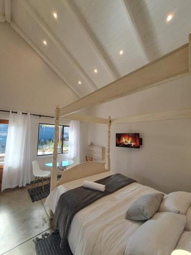 a bedroom with a large bed with a fireplace at Cooper Cottage in Howick