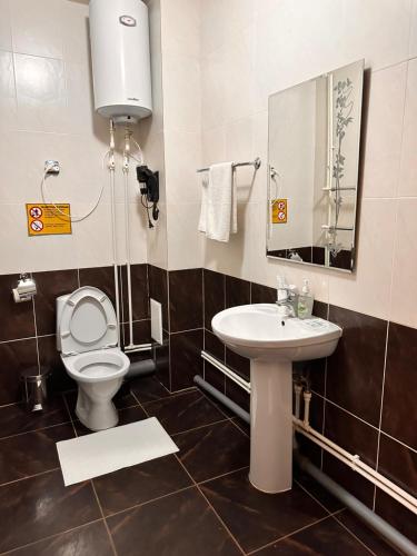 a bathroom with a toilet and a sink at Silk Way Hotel in Kokshetau