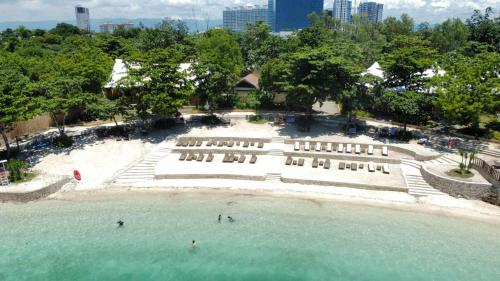 an aerial view of a beach with chairs and water at Flow 8 Suites at Mactan Newtown in Punta Engaño