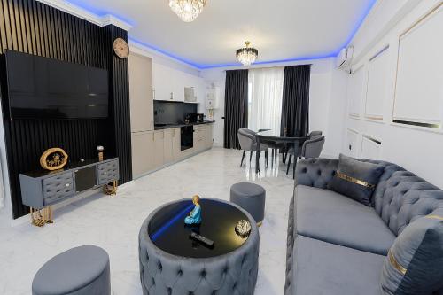 a living room with a couch and a tv and a table at Aparthotel C37 - Alezzi Odyssey Pool & Spa Resort in Mamaia Nord
