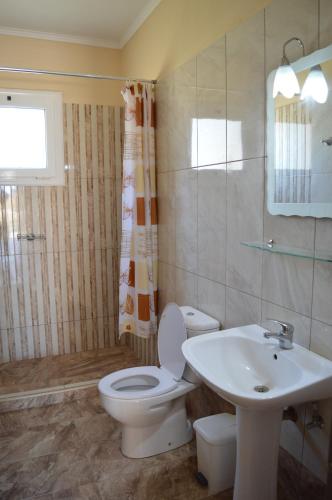 a bathroom with a toilet and a sink at Garden View Apartments in Anaxos