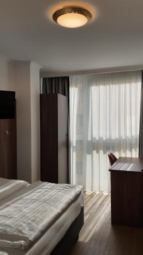 a bedroom with a bed and a large window at Hotel Aurbacher Hof GmbH in Munich