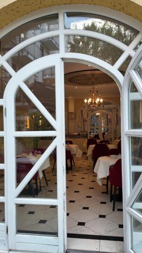 a dining room with tables and chairs and a window at Hotel Aurbacher Hof GmbH in Munich