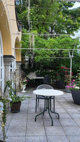 a table and a bench on a patio with plants at Hotel Aurbacher Hof GmbH in Munich