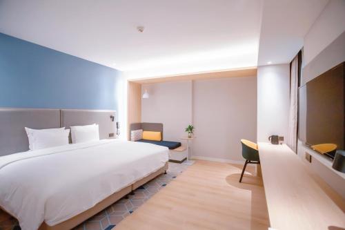 a hotel room with a large bed and a tv at Holiday Inn Express Jinan Airport Zone by IHG in Jinan