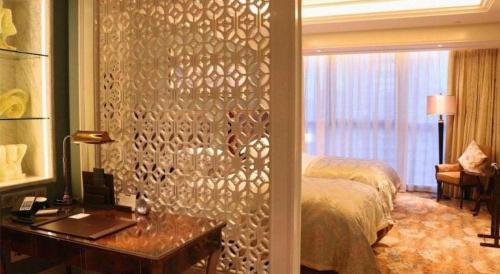 a bedroom with a bed and a desk and a window at Xian Jue Vu Hotel in Xi'an