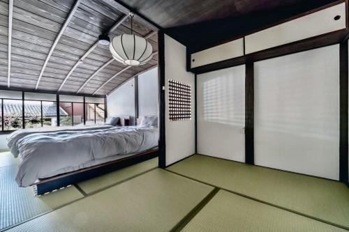 ein Schlafzimmer mit einem Bett und einem großen Fenster in der Unterkunft ann長良 in Gifu