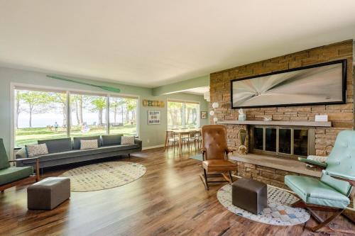 a living room with a fireplace and a large tv at All the Waters Retro Home on Lake Michigan- Your Own PRIVATE BEACH in Benton Harbor