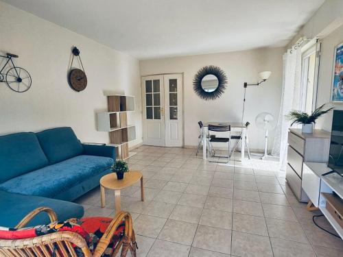 un salon avec un canapé bleu et une table dans l'établissement Beau 3 pièces à Nice - terrasses et piscine, à Nice