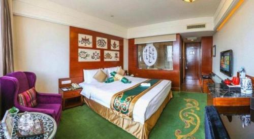 a hotel room with a bed and a purple chair at Hohhot Inner Mongolia Hotel in Hohhot