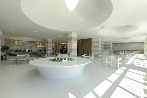 a large white room with white tables and chairs at Sol Beach Namhae in Namhae