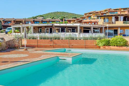 una piscina con acqua blu di fronte a un edificio di Casa Verdiana Golfo di Marinella Sardegna a Marinella