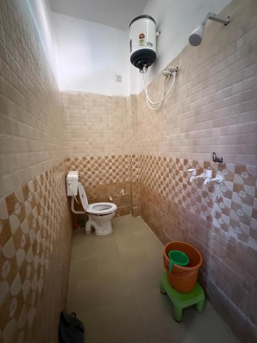 a bathroom with a toilet and a light on the ceiling at Kanak Bihari Yatri Niwas, 100 Meter Ram Ki Paidi, Saryu River in Ayodhya