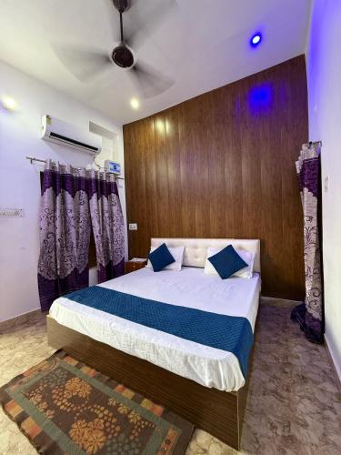 a bedroom with a large bed with blue pillows at Kanak Bihari Yatri Niwas, 100 Meter Ram Ki Paidi, Saryu River in Ayodhya