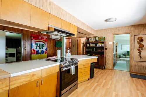 a kitchen with wooden cabinets and a stove top oven at All the Waters Retro Home on Lake Michigan- Your Own PRIVATE BEACH in Benton Harbor