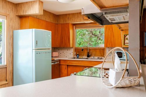 a kitchen with a white refrigerator and wooden cabinets at All the Waters Retro Home on Lake Michigan- Your Own PRIVATE BEACH in Benton Harbor