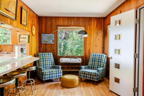 a kitchen with two blue chairs and a counter at All the Waters Retro Home on Lake Michigan- Your Own PRIVATE BEACH in Benton Harbor