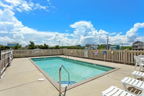 a swimming pool with chairs and a fence at YC301 - Life's Porpoise in Whalebone