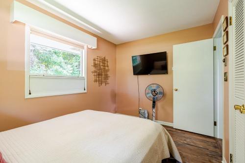 a bedroom with a bed and a window and a fan at All the Waters Retro Home on Lake Michigan- Your Own PRIVATE BEACH in Benton Harbor