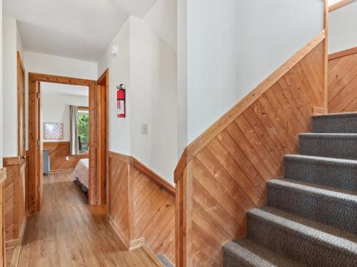 a staircase in a home with wooden floors at 2030 - Horizon`s Summit in Duck