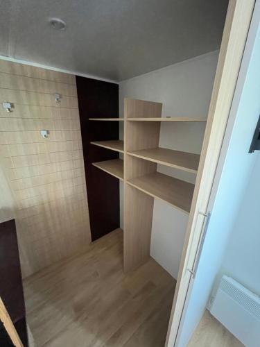a walk in closet with wooden shelves at Camping De Collignon in Cherbourg en Cotentin