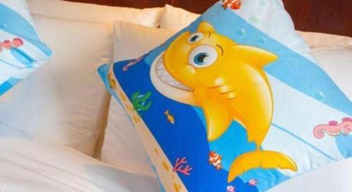 a book with a cartoon fish on it on a bed at Quanzhou Guest House Hotel in Quanzhou
