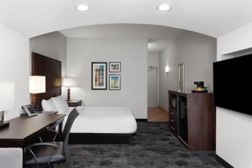 a hotel room with a bed and a desk at La Quinta by Wyndham Columbus - Edinburgh in Columbus