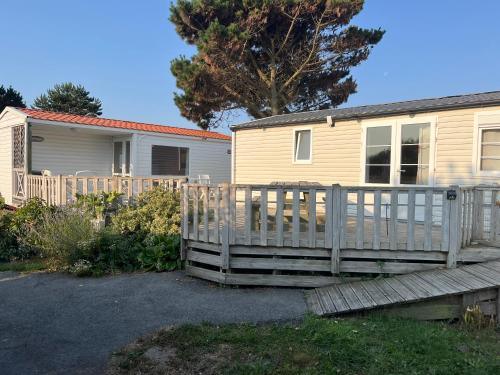 a house with a wooden deck and a house at Camping De Collignon in Cherbourg en Cotentin