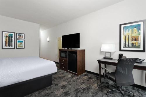a hotel room with a bed and a desk with a computer at La Quinta by Wyndham Columbus - Edinburgh in Columbus
