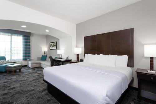 a bedroom with a large bed and a living room at La Quinta by Wyndham Columbus - Edinburgh in Columbus