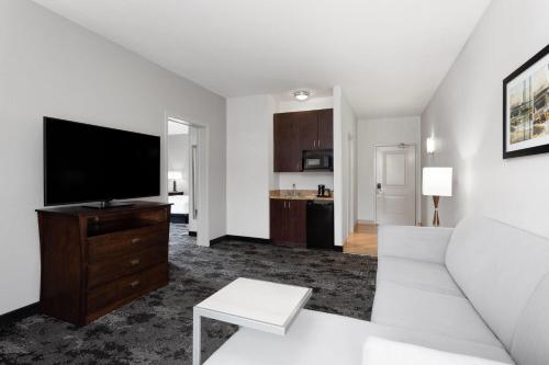 a living room with a couch and a flat screen tv at La Quinta by Wyndham Columbus - Edinburgh in Columbus