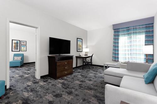 a living room with a couch and a flat screen tv at La Quinta by Wyndham Columbus - Edinburgh in Columbus