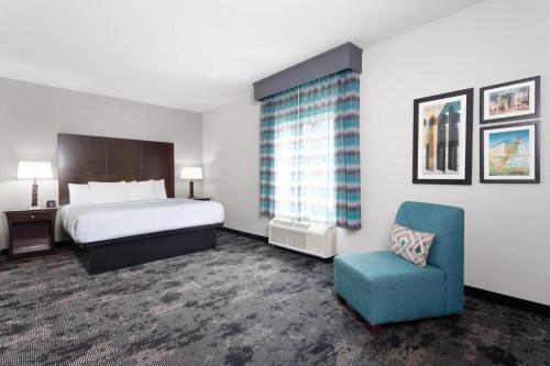 a hotel room with a bed and a chair at La Quinta by Wyndham Columbus - Edinburgh in Columbus