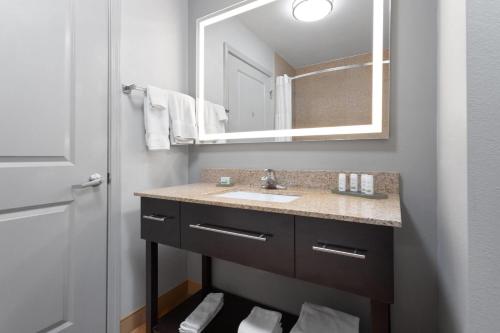 a bathroom with a sink and a mirror at La Quinta by Wyndham Columbus - Edinburgh in Columbus