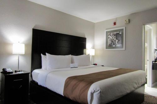 a large bed in a hotel room with two lamps at Quality Inn & Suites Kissimmee by The Lake in Orlando