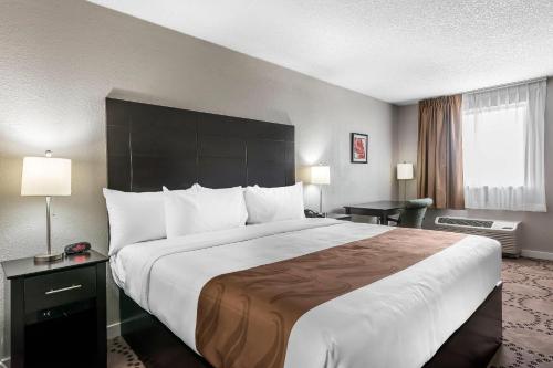 a hotel room with a large bed and a large window at Quality Inn & Suites Kissimmee by The Lake in Orlando