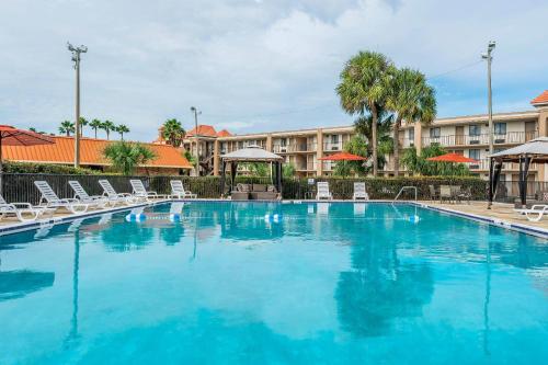 a large swimming pool with chairs and a hotel at Quality Inn & Suites Kissimmee by The Lake in Orlando