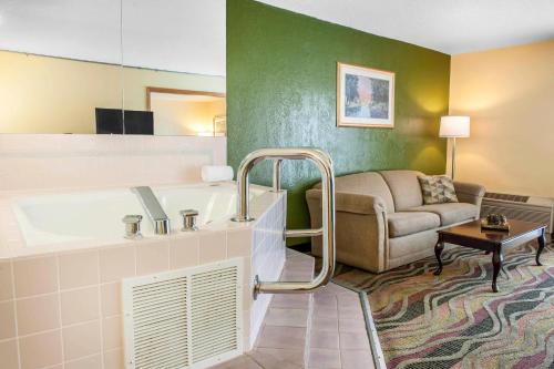 a hotel room with a tub and a couch at Quality Inn Conference Center Logansport in Logansport