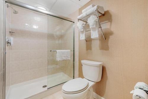 a bathroom with a toilet and a glass shower at Clarion Hotel & Conference Center in Toms River